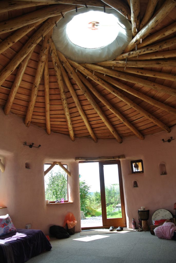 Inside the straw bale roundhouse with a great view of the central skylight and reciprocating frame roof